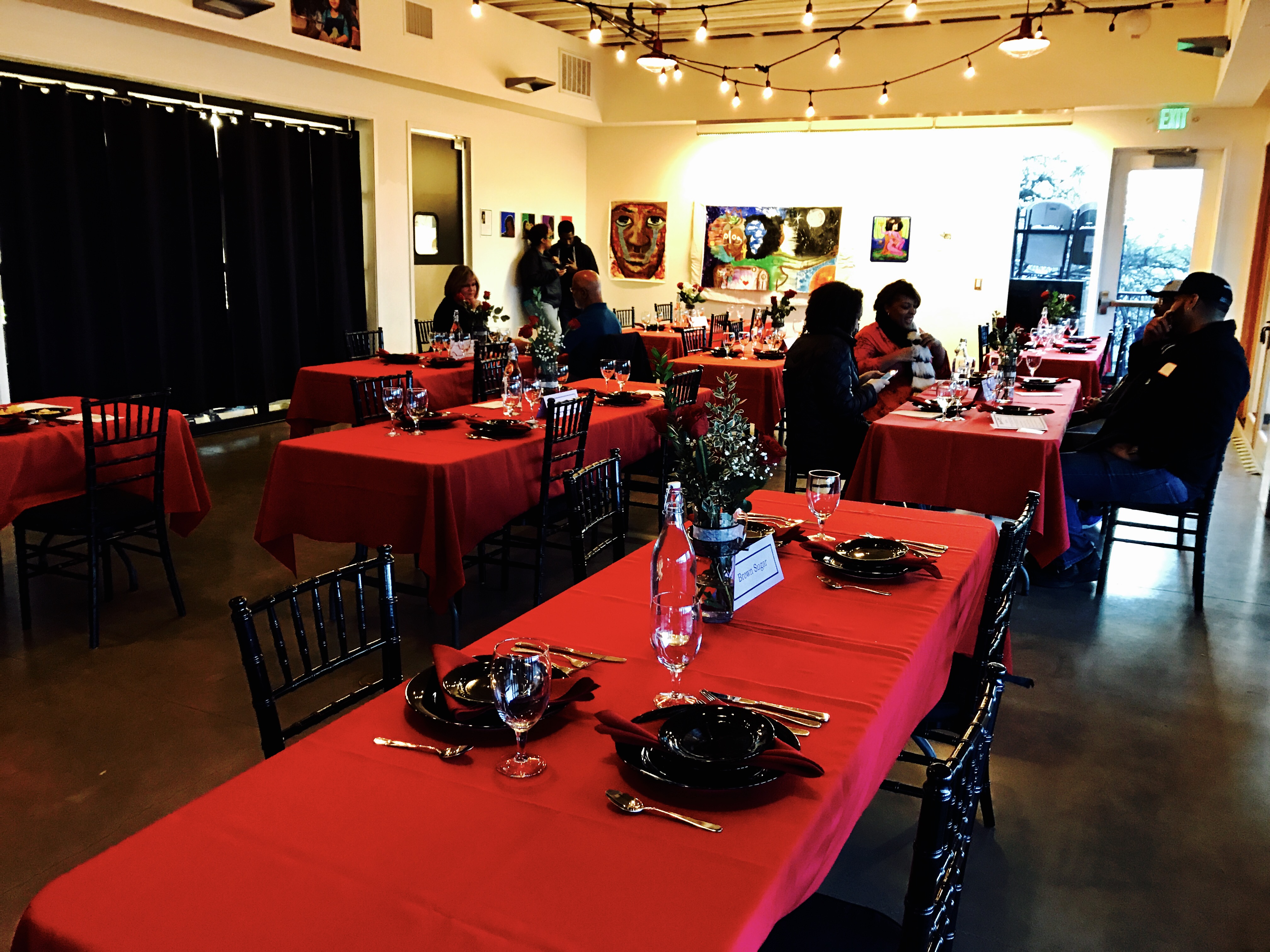 People at red tables with black plates waiting for Valentine's Cooking Class and Dinner