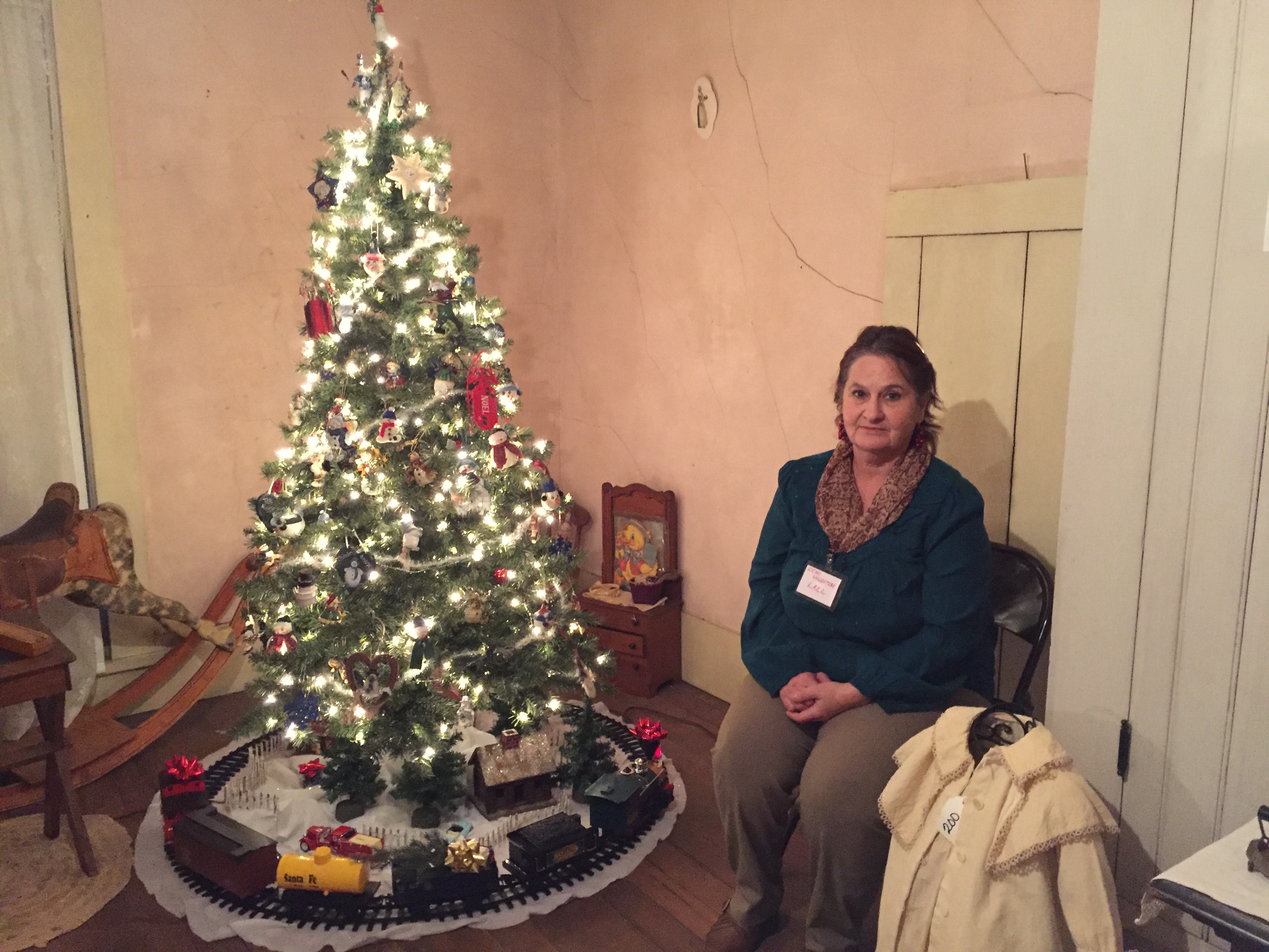 woman sitting in front of Chirstmas tree at Winterville Christ