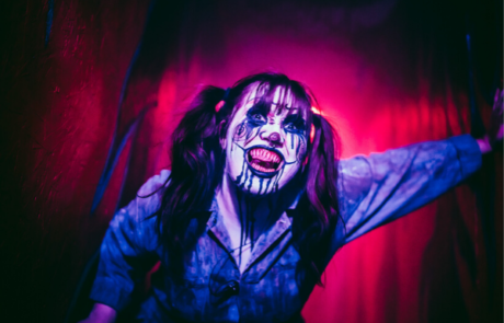 Girl wearing scary clown makeup for a Halloween attraction