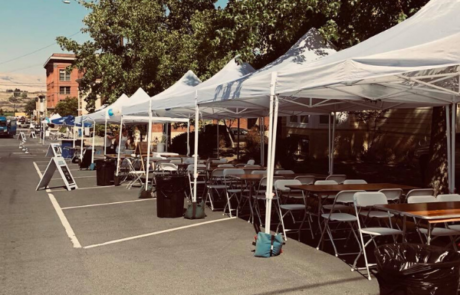 row of tents set up with tables and chairs