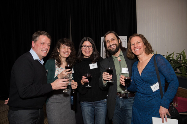 Smiling event guests with glasses of red wine