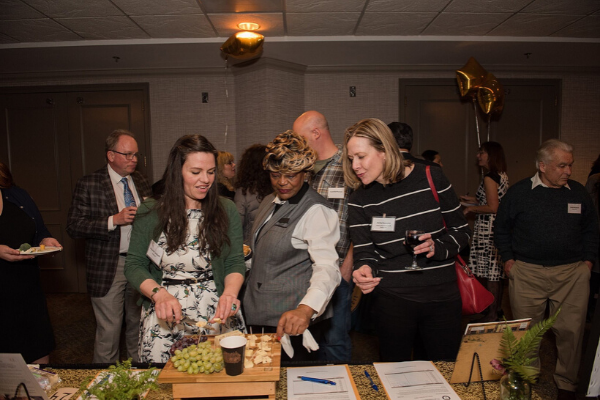 Event guests grazing a fruit & cheese platter